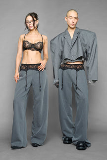 model wearing grey baggy suiting pants with garter lace waist detail