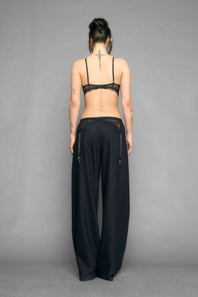 model wearing black baggy suiting pants with garter lace waist detail