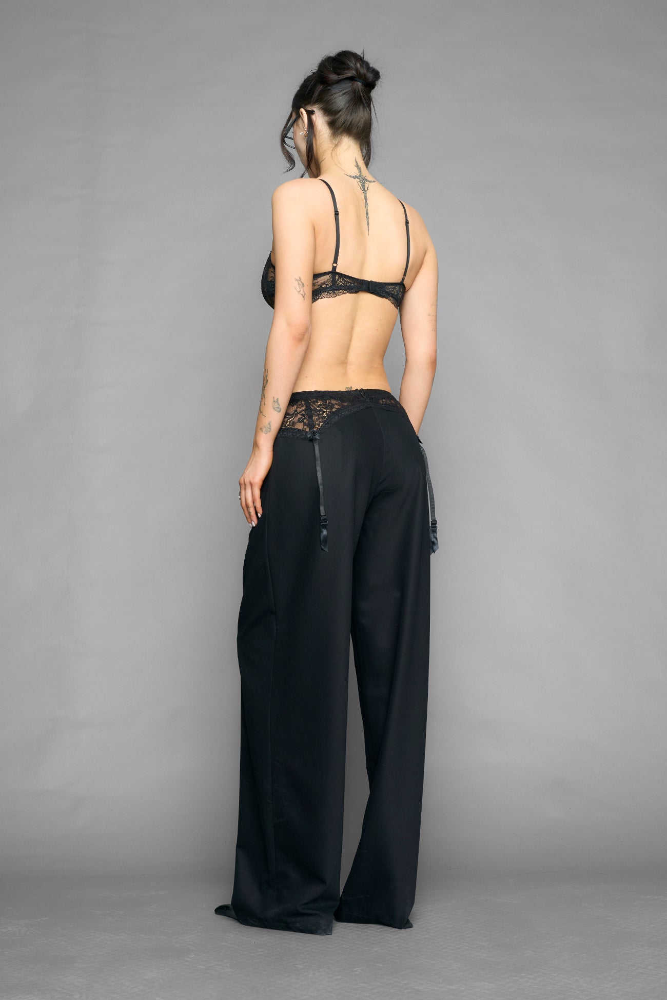 model wearing black baggy suiting pants with garter lace waist detail