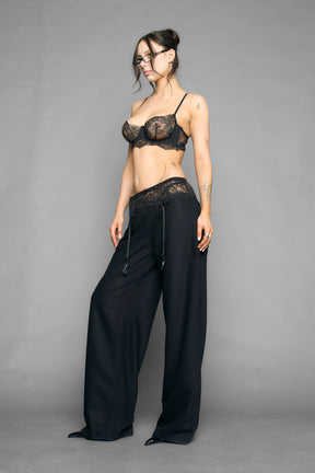 model wearing black baggy suiting pants with garter lace waist detail