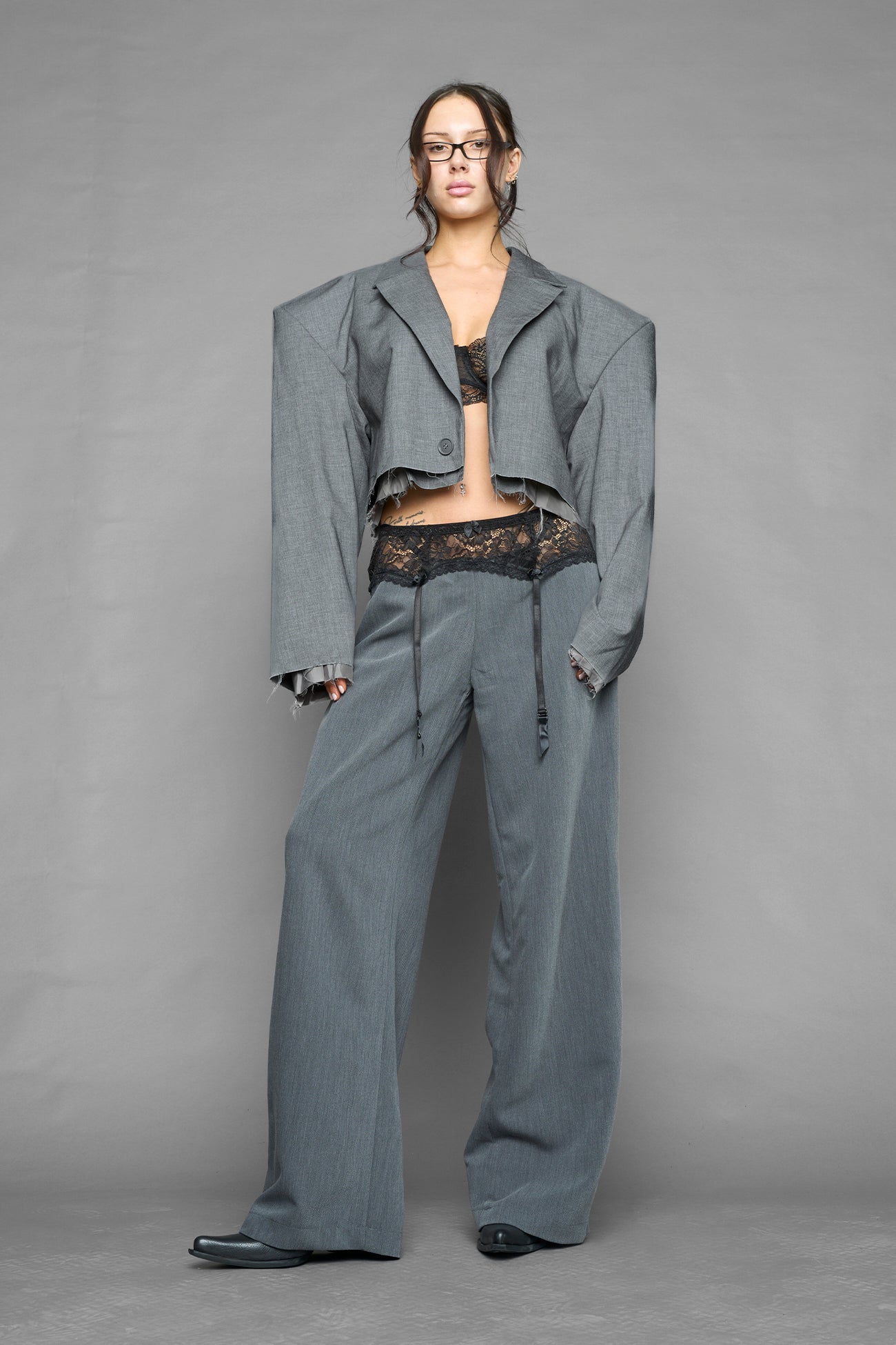 model wearing grey baggy suiting pants with garter lace waist detail