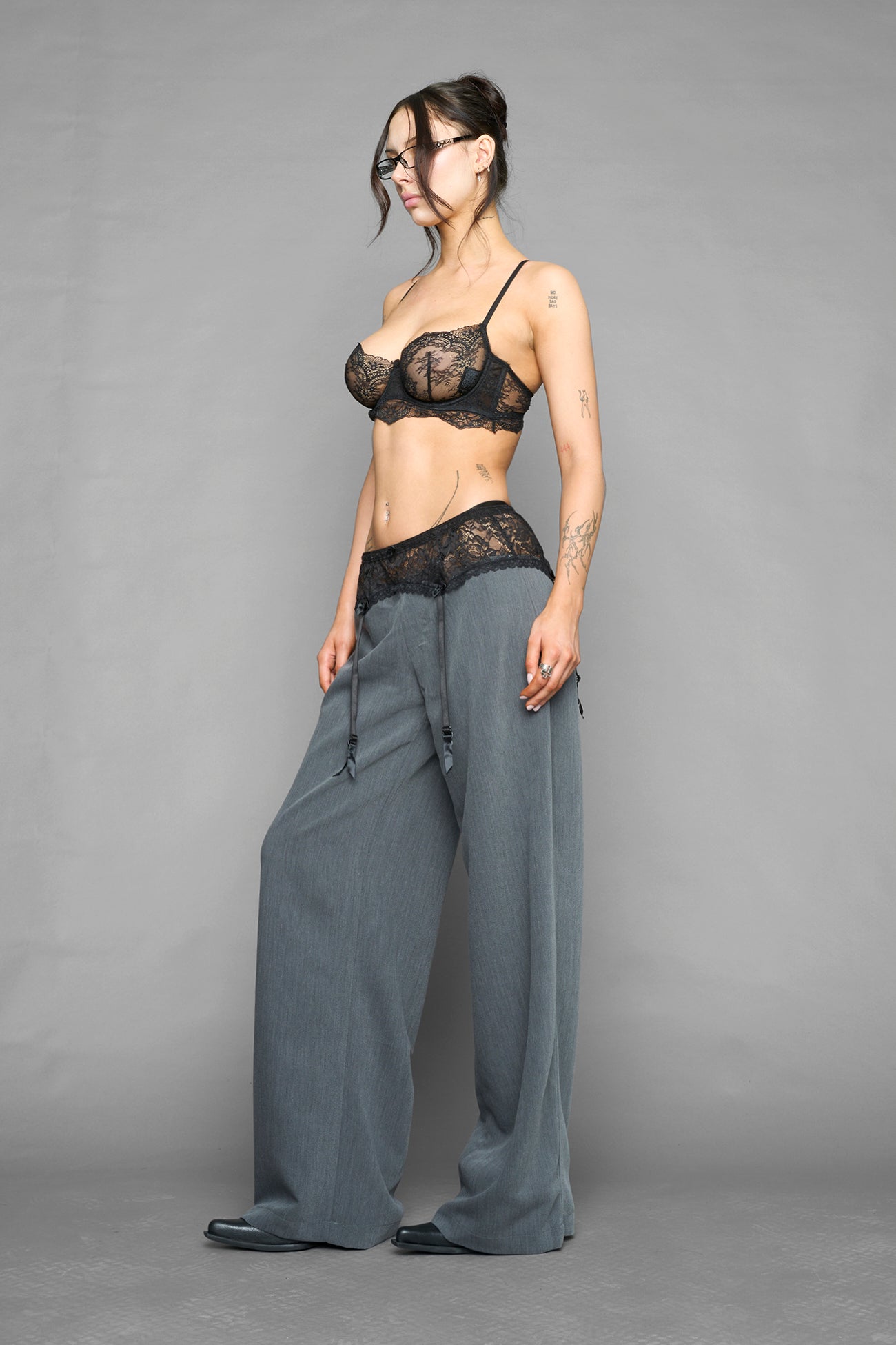 model wearing grey baggy suiting pants with garter lace waist detail