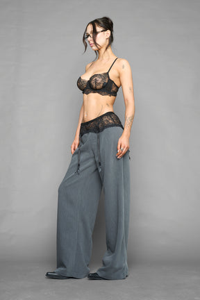 model wearing grey baggy suiting pants with garter lace waist detail