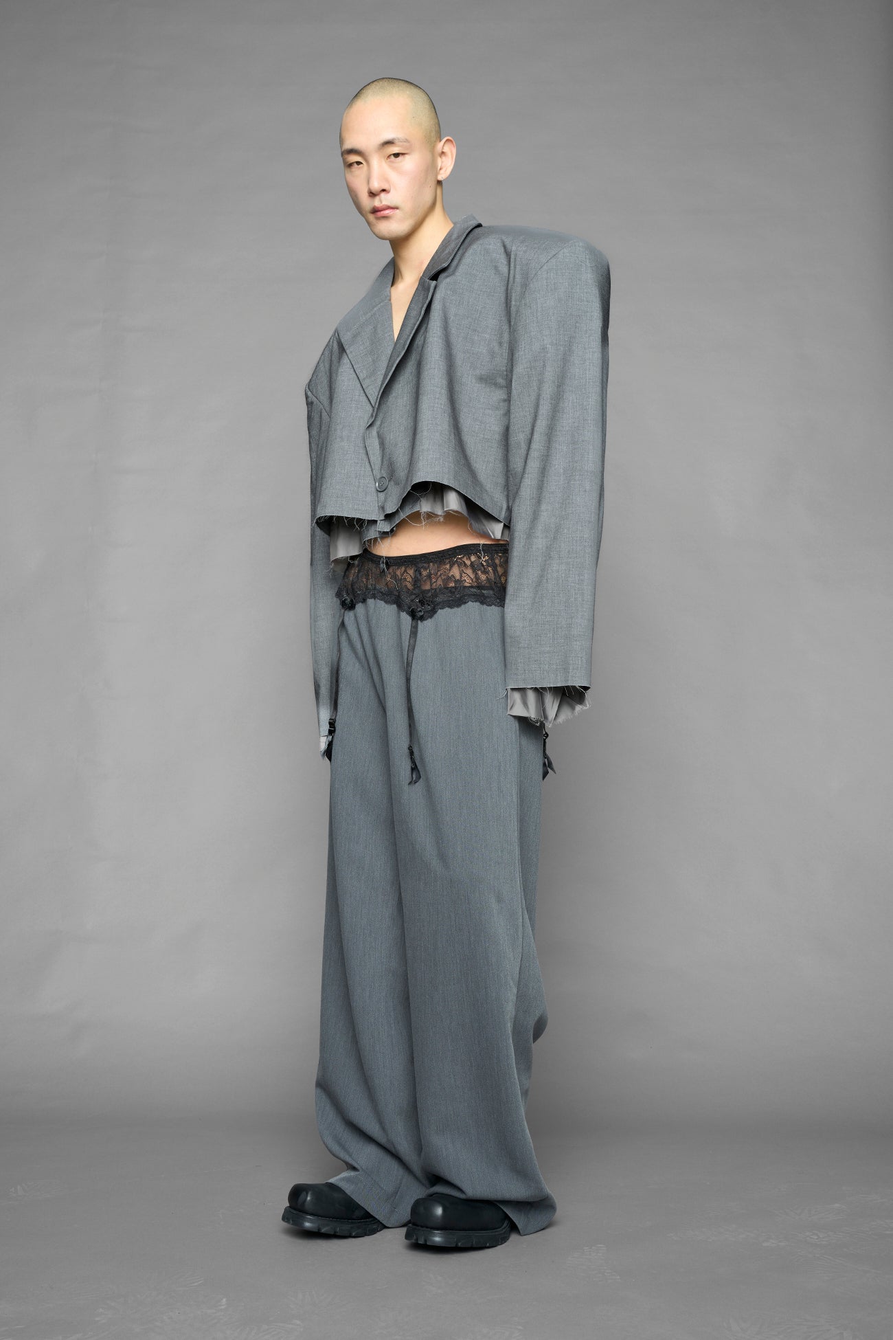 model wearing grey baggy suiting pants with garter lace waist detail