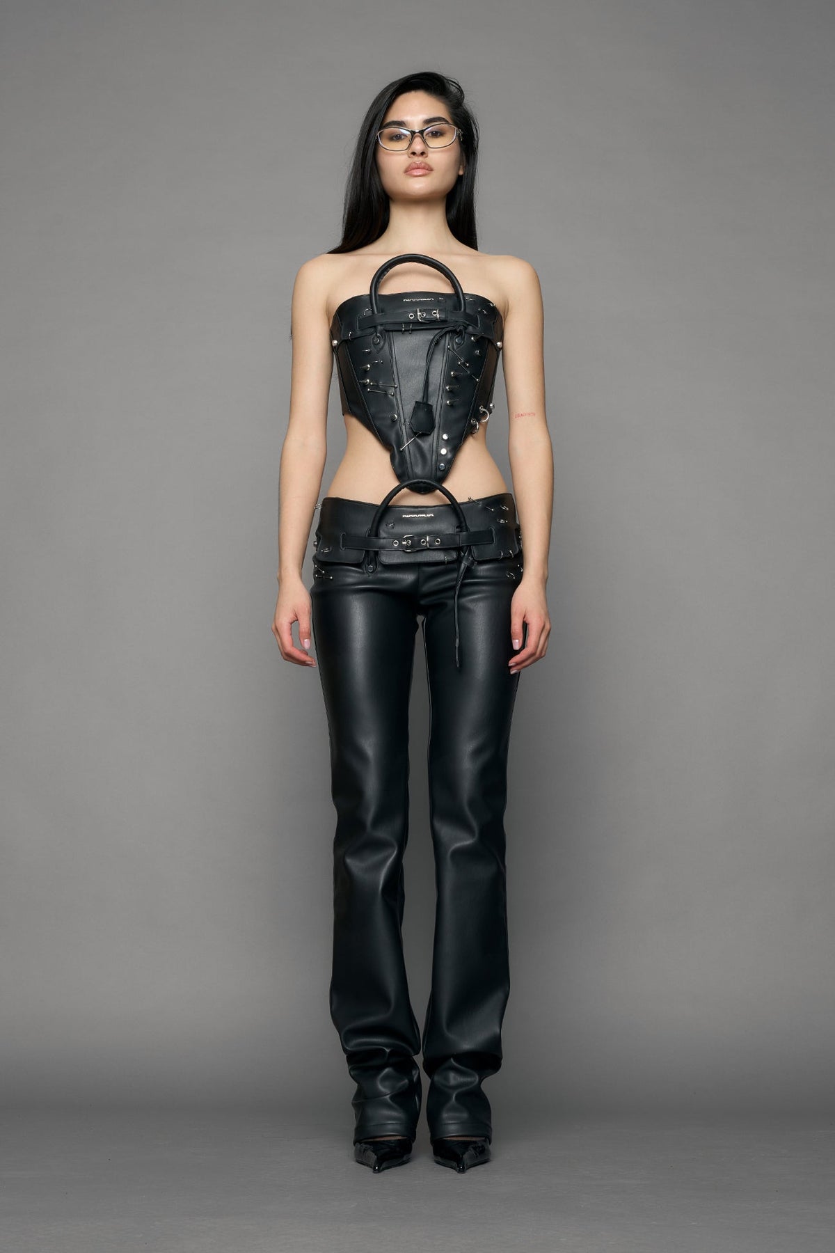 model wearing black pu leather studded handbag pants