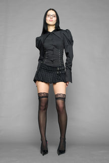 black print pleated micro mini skirt with low rise waistband and buckle strap detail worn by model studio ecommerce image
