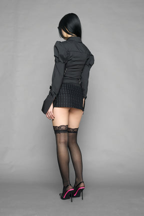 black print pleated micro mini skirt with low rise waistband and buckle strap detail worn by model studio ecommerce image