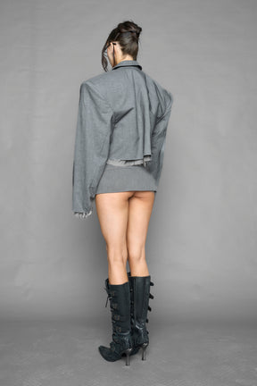 grey pleated micro mini skirt with low rise waistband and buckle strap detail worn by model studio ecommerce image