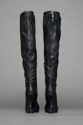 Black leather wedge boot on a gray background