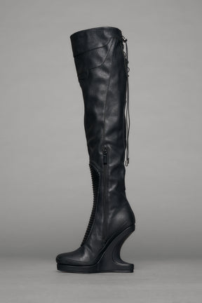 Black leather wedge boot on a gray background