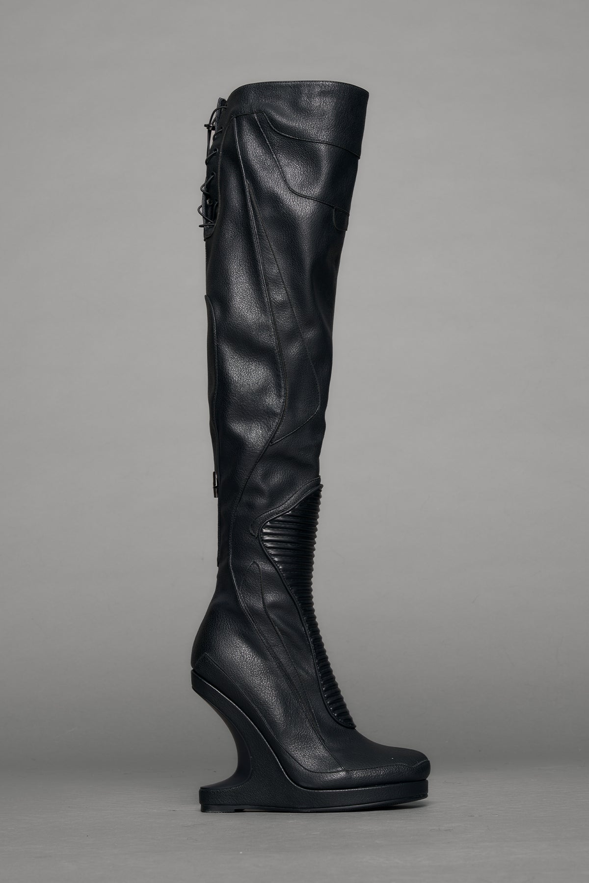 Black leather wedge boot on a gray background
