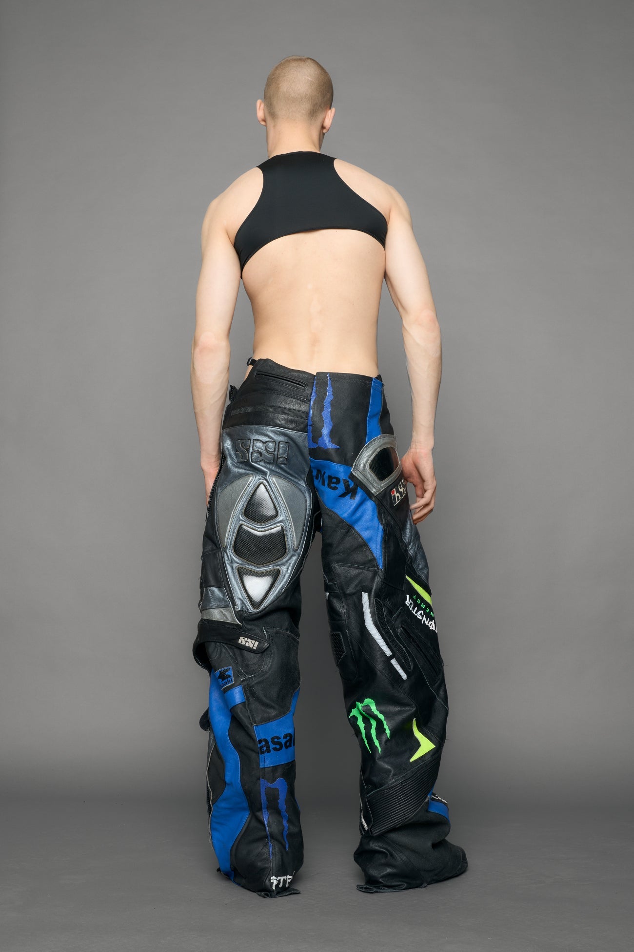 Person wearing a black bodysuit with cut-out design on a gray background