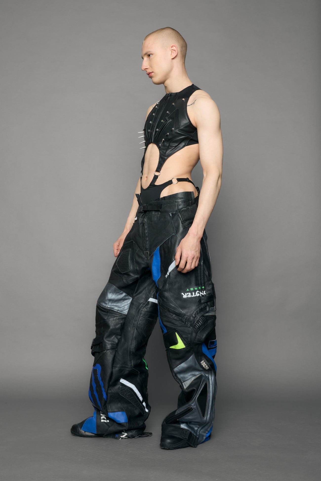 Person wearing a black bodysuit with cut-out design on a gray background