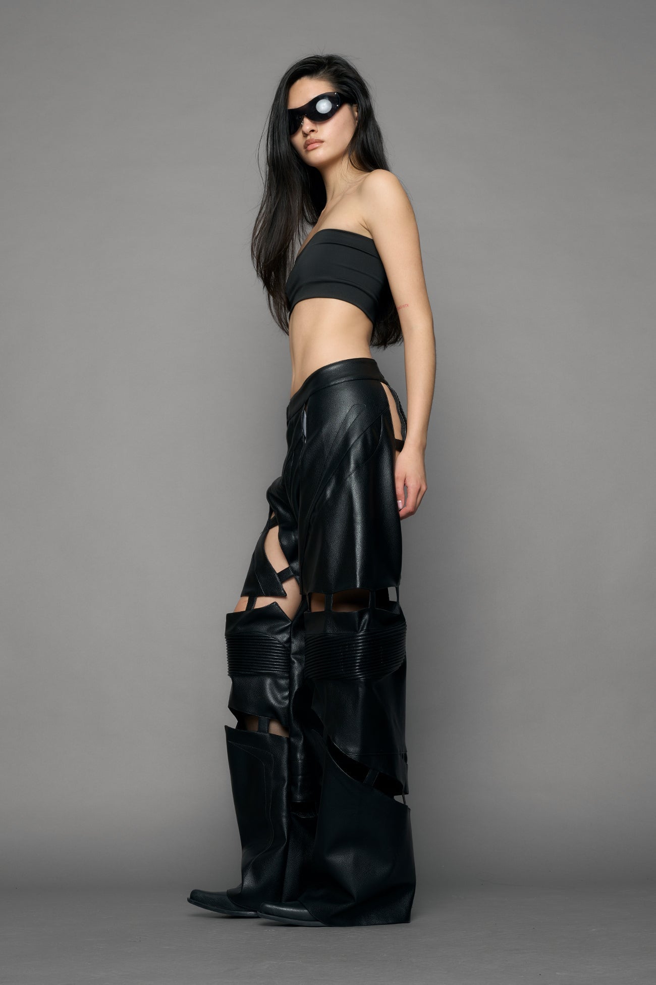 model wearing black pu leather pants with cut out details