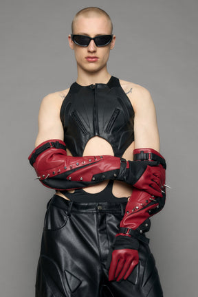 Model wearing a red studded leather gloves with silver and black details