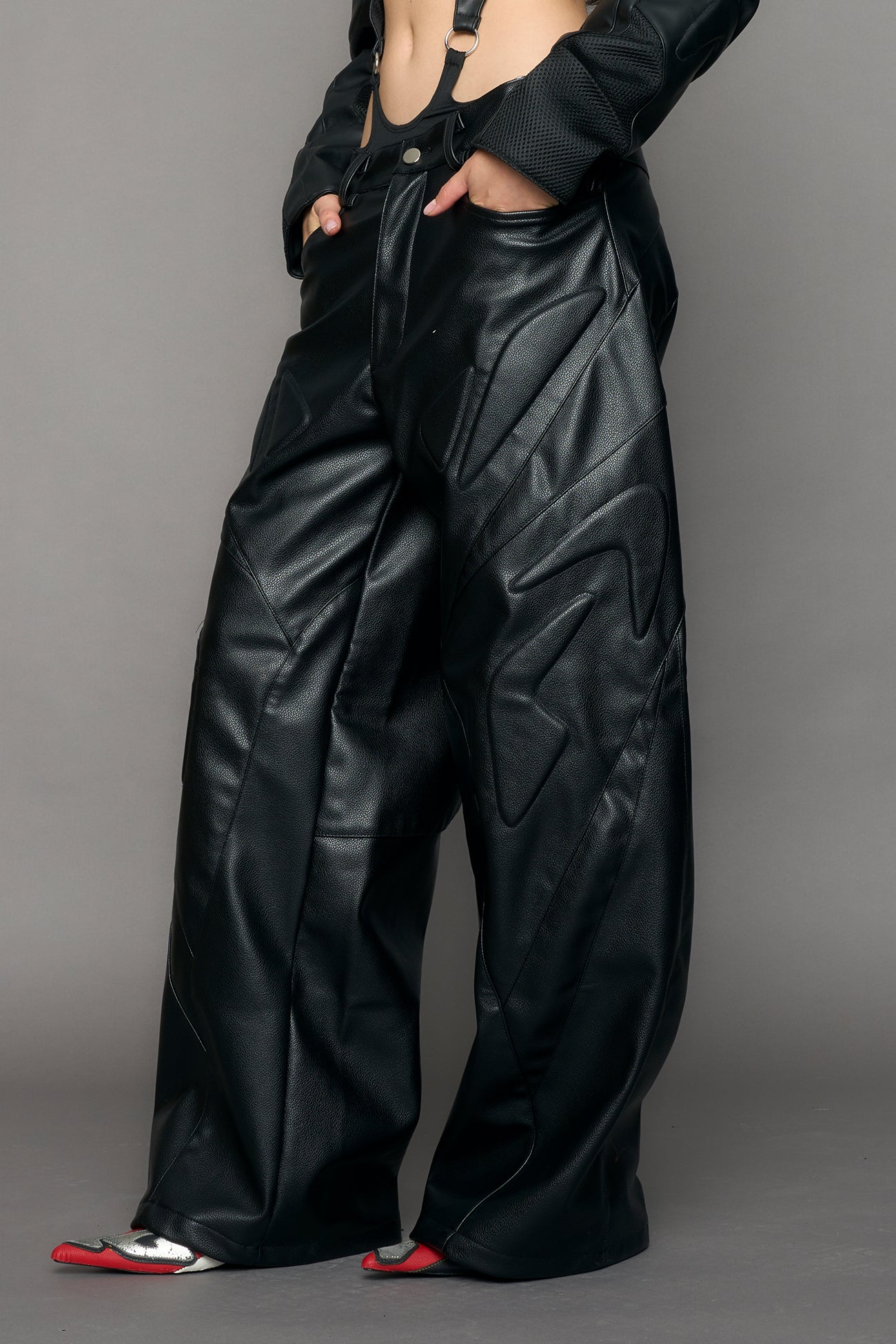 model wearing black oversize pu leather pants with moto style highlights