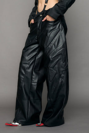 model wearing black oversize pu leather pants with moto style highlights