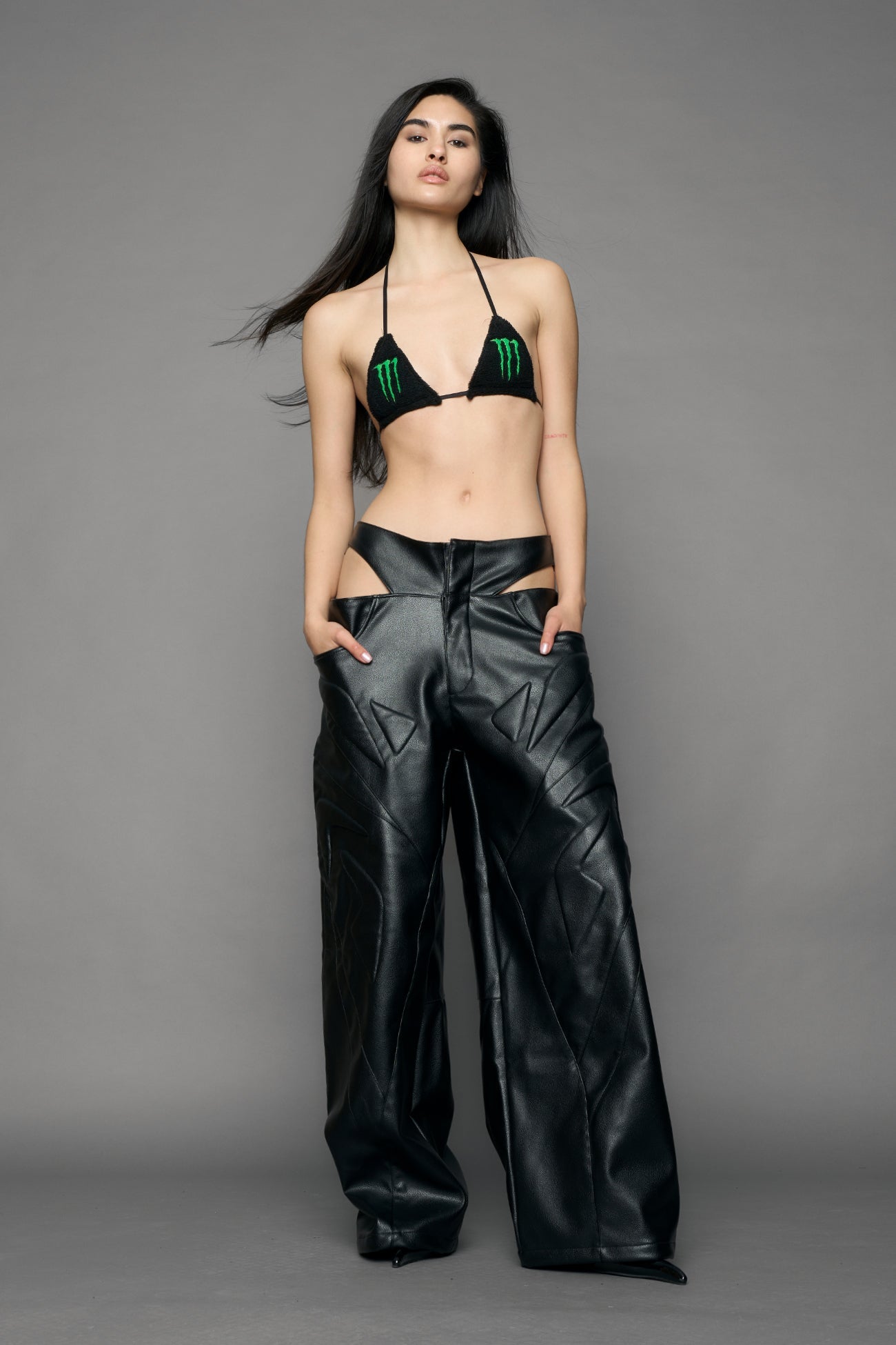 model wearing black pu leather trousers with thong design and moto style highlights