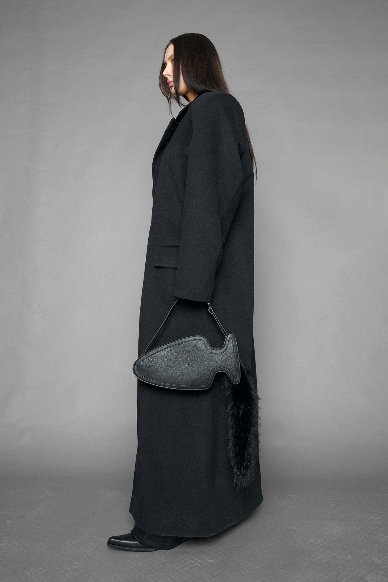 black butt plug bag with adjustable strap and faux fur detail worn as shoulder bag studio ecommerce image