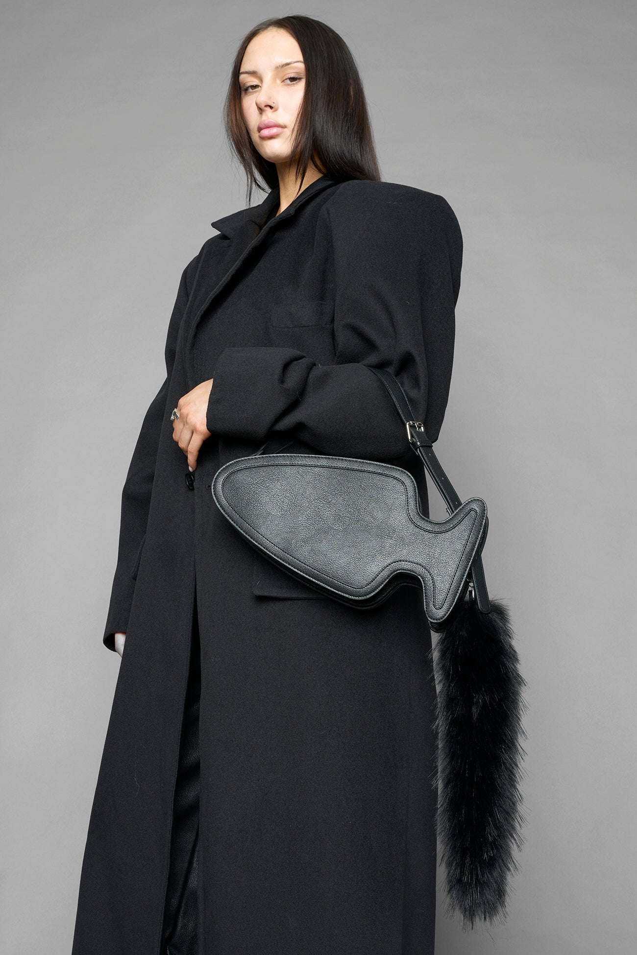 black butt plug bag with adjustable strap and faux fur detail worn as shoulder bag studio ecommerce image