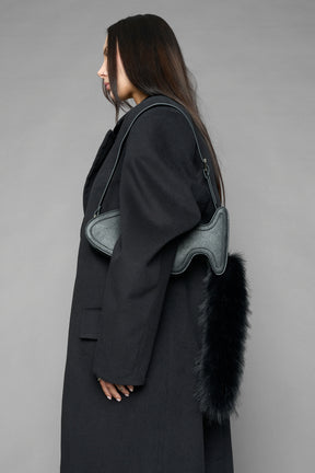 black butt plug bag with adjustable strap and faux fur detail worn as shoulder bag studio ecommerce image