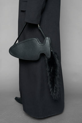 black butt plug bag with adjustable strap and faux fur detail worn as shoulder bag studio ecommerce image