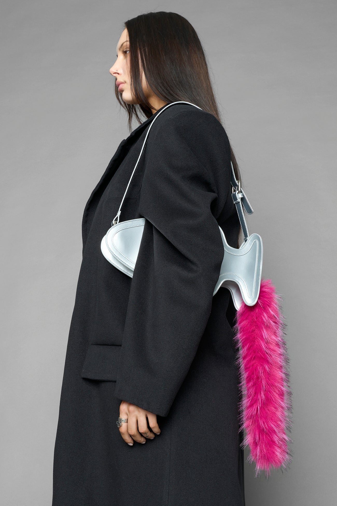 silver butt plug bag with adjustable strap and faux fur detail worn as shoulder bag studio ecommerce image