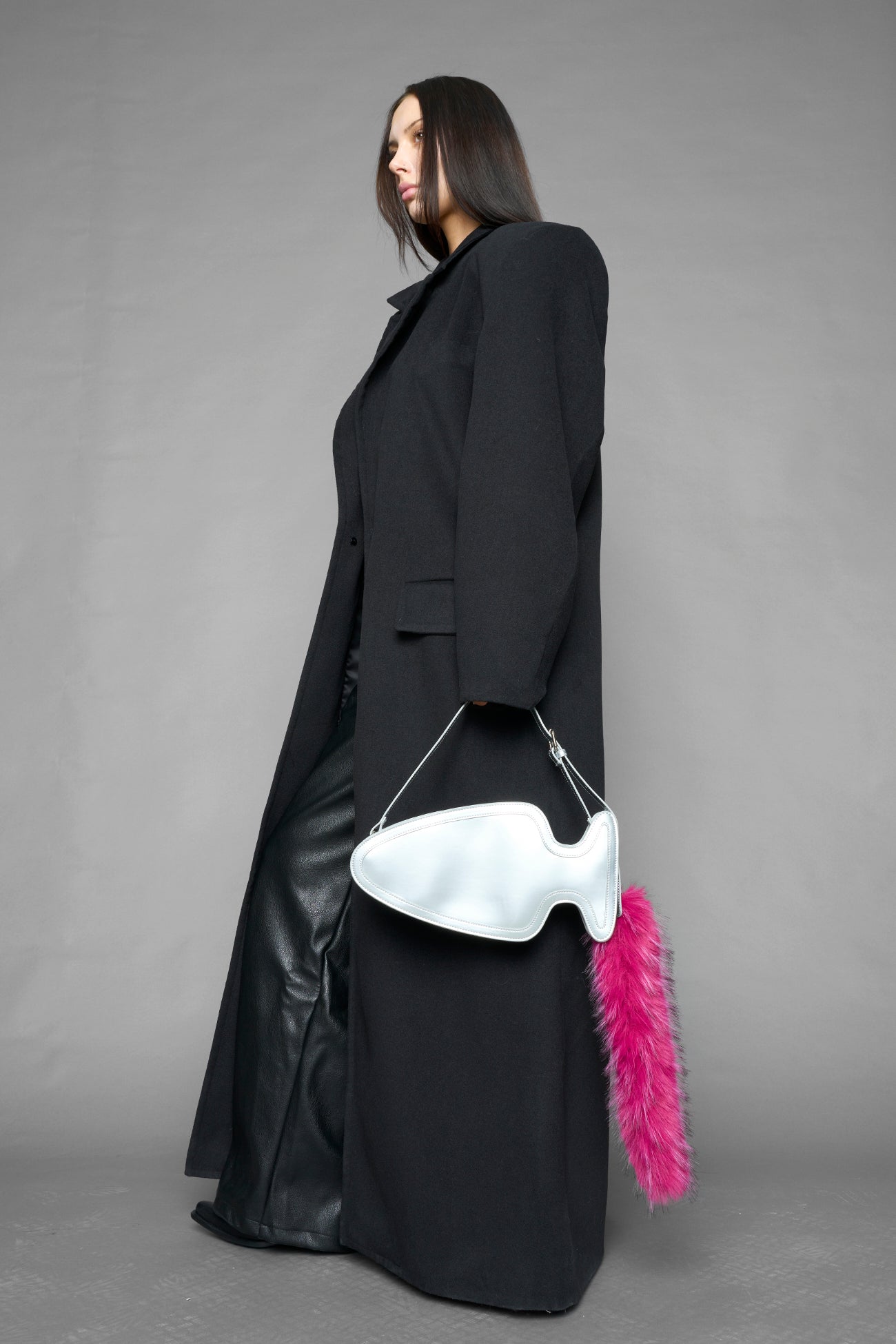 silver butt plug bag with adjustable strap and faux fur detail worn as shoulder bag studio ecommerce image