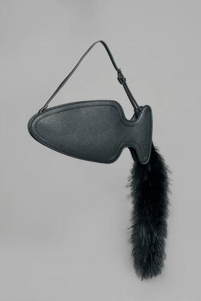 black butt plug bag with adjustable strap and faux fur detail worn as shoulder bag studio ecommerce image
