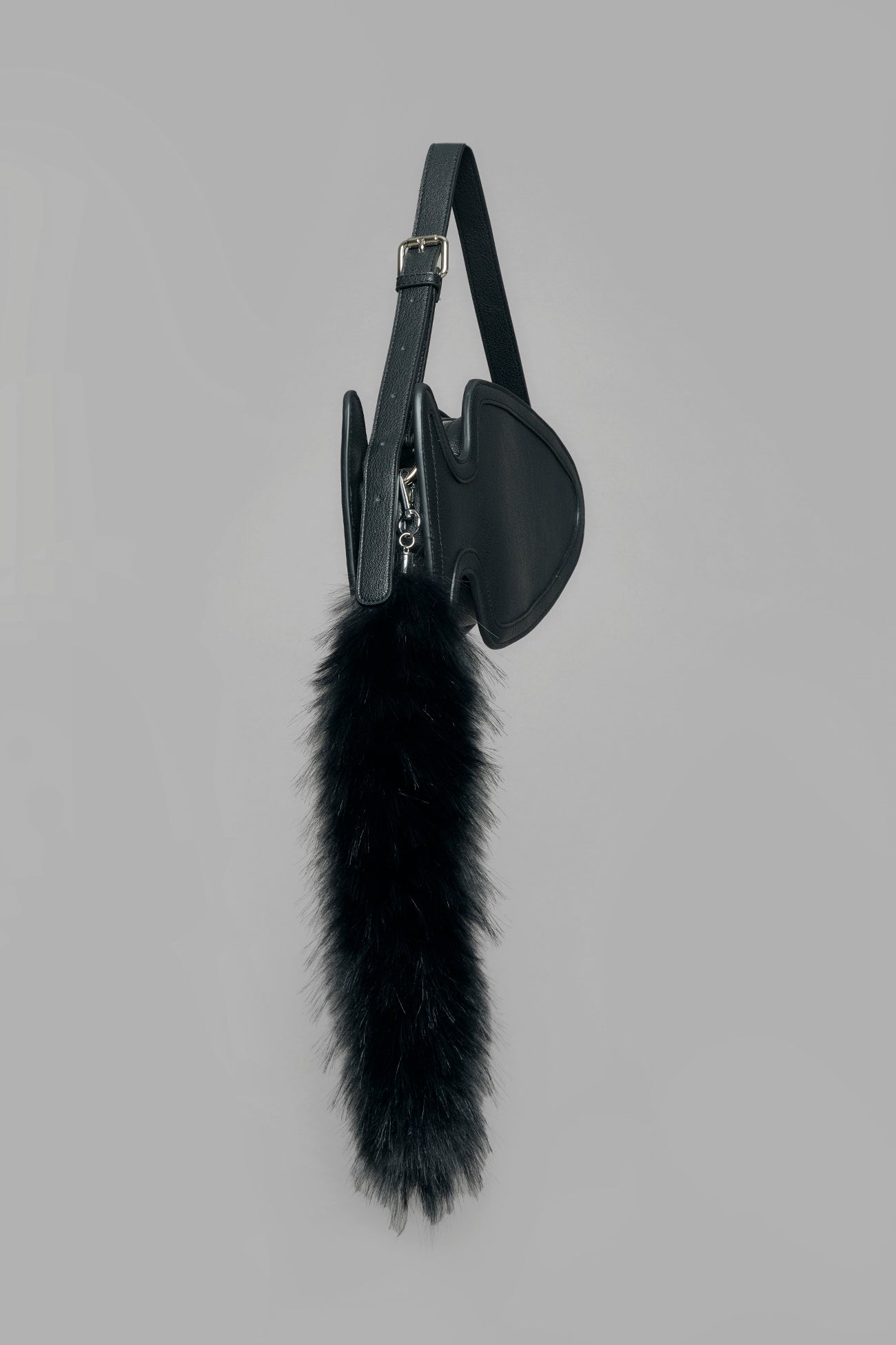 black butt plug bag with adjustable strap and faux fur detail worn as shoulder bag studio ecommerce image