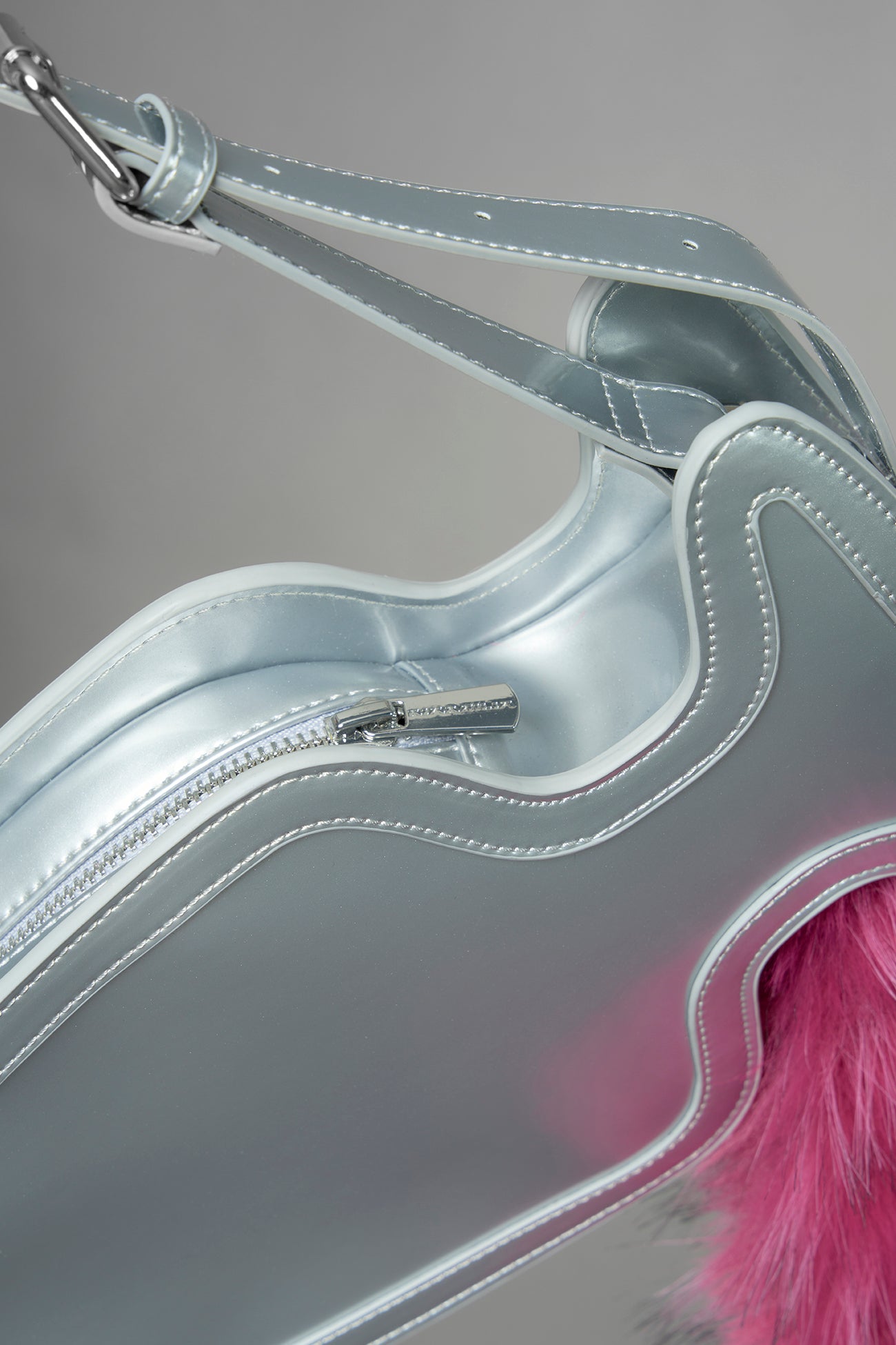 silver butt plug bag with adjustable strap and faux fur detail worn as shoulder bag studio ecommerce image