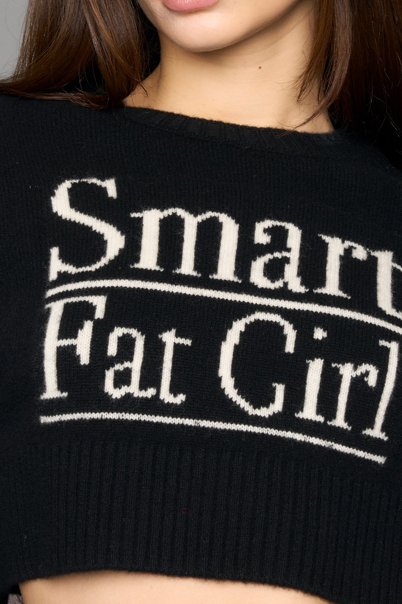Woman wearing a black wool sweater with text on a gray background