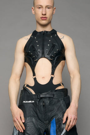 Person wearing a black bodysuit with cut-out design on a gray background