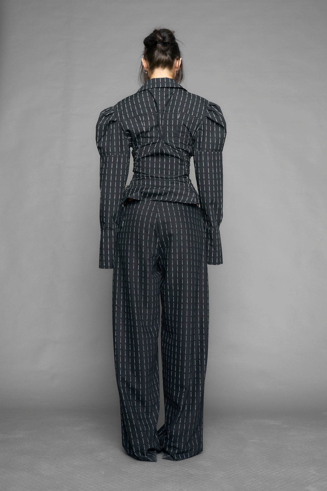 black print puff shoulder blouse with corset lace up sides and button front worn by model studio ecommerce image