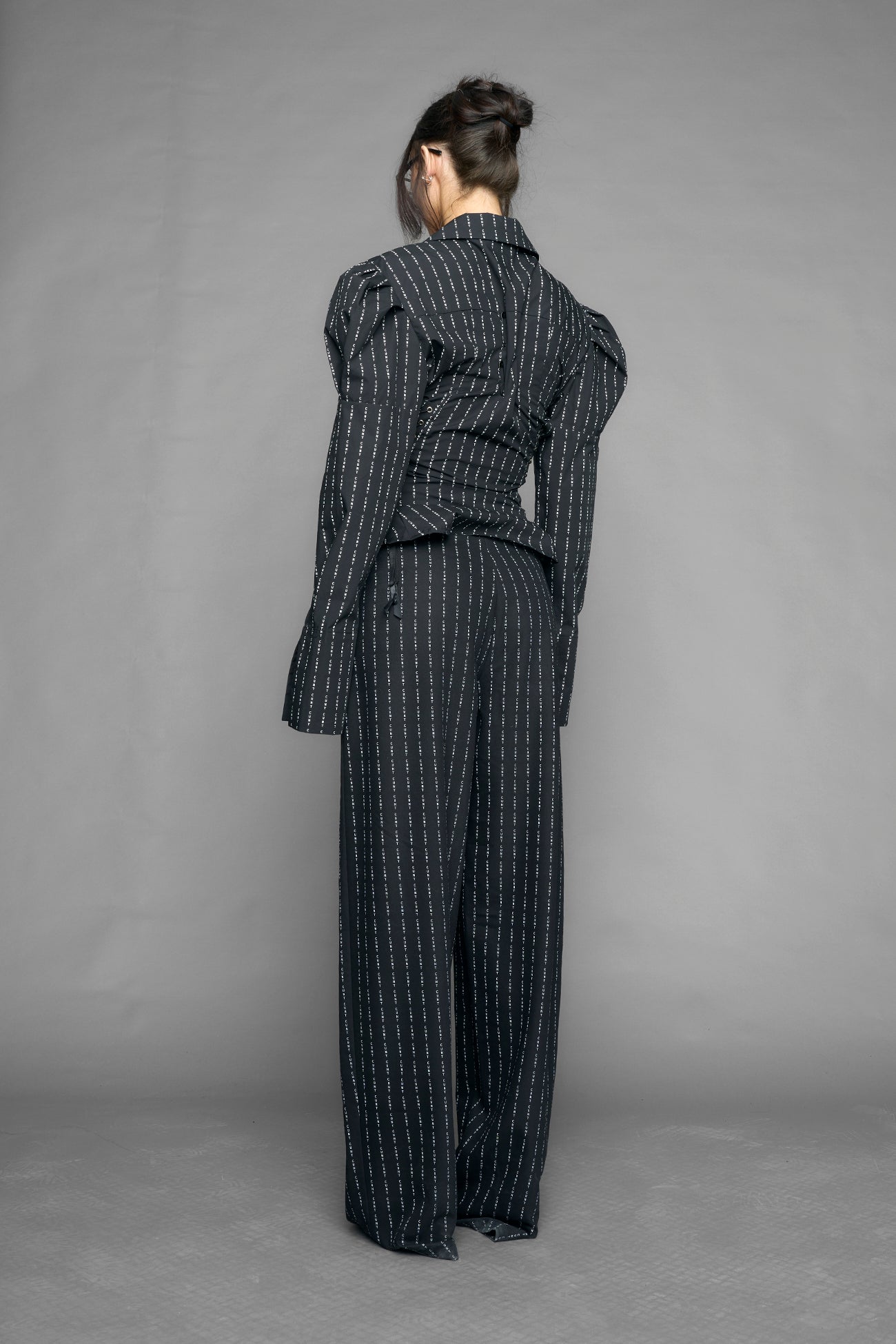 black print puff shoulder blouse with corset lace up sides and button front worn by model studio ecommerce image