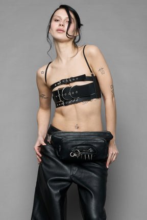 black vulva bum bag with adjustable strap and metal spike detailing worn as crossbody and shoulder bag studio ecommerce image