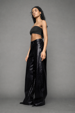 model wearing baggy suiting pants in black croc texture against a gray background