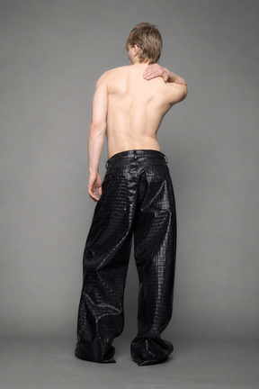 model wearing baggy suiting pants in black croc texture against a gray background