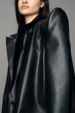 model wearing black pu leather coat with sharp shoulder design