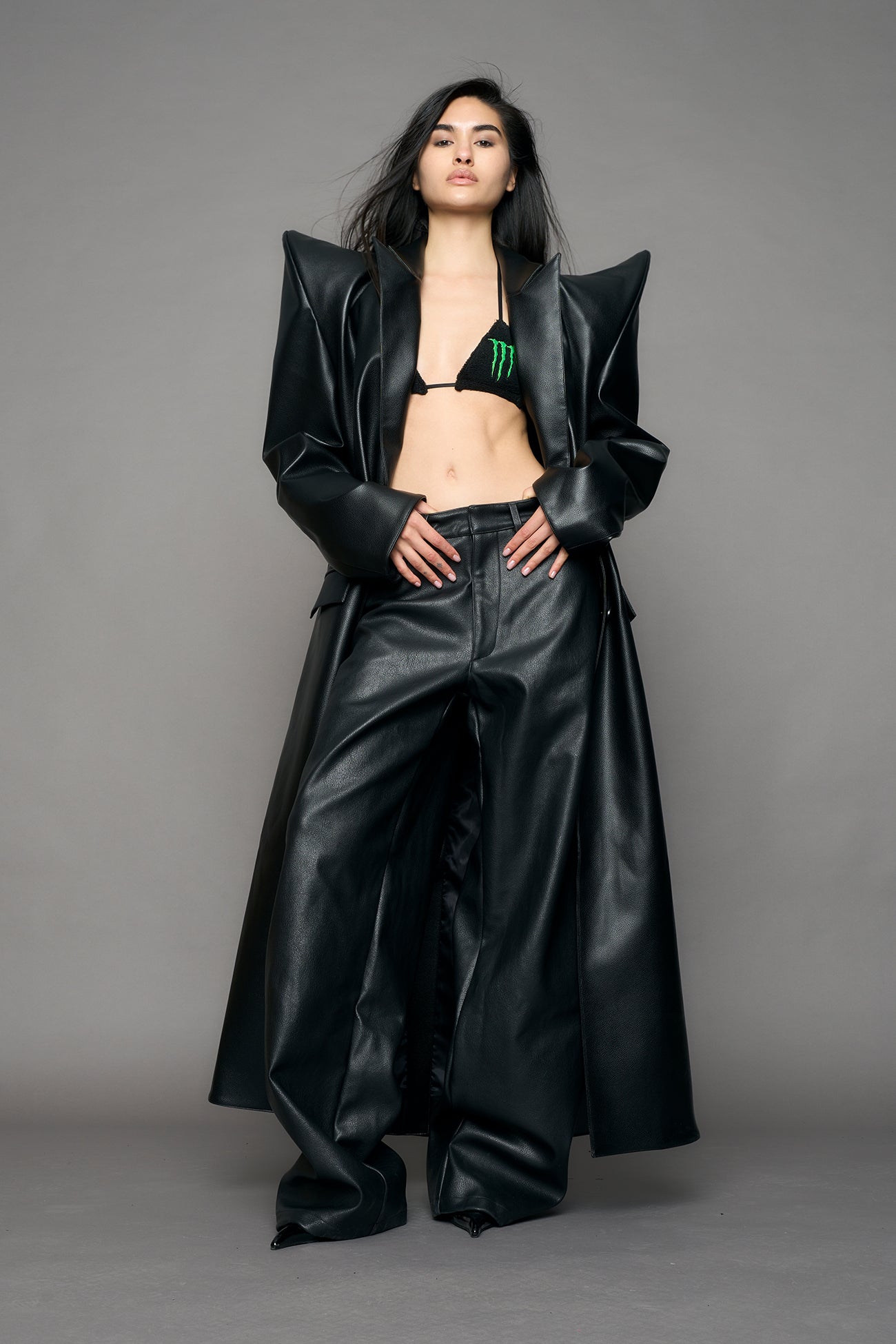 model wearing black pu leather coat with sharp shoulder design