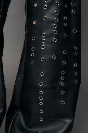 model wearing black pu leather pants with eyelet details