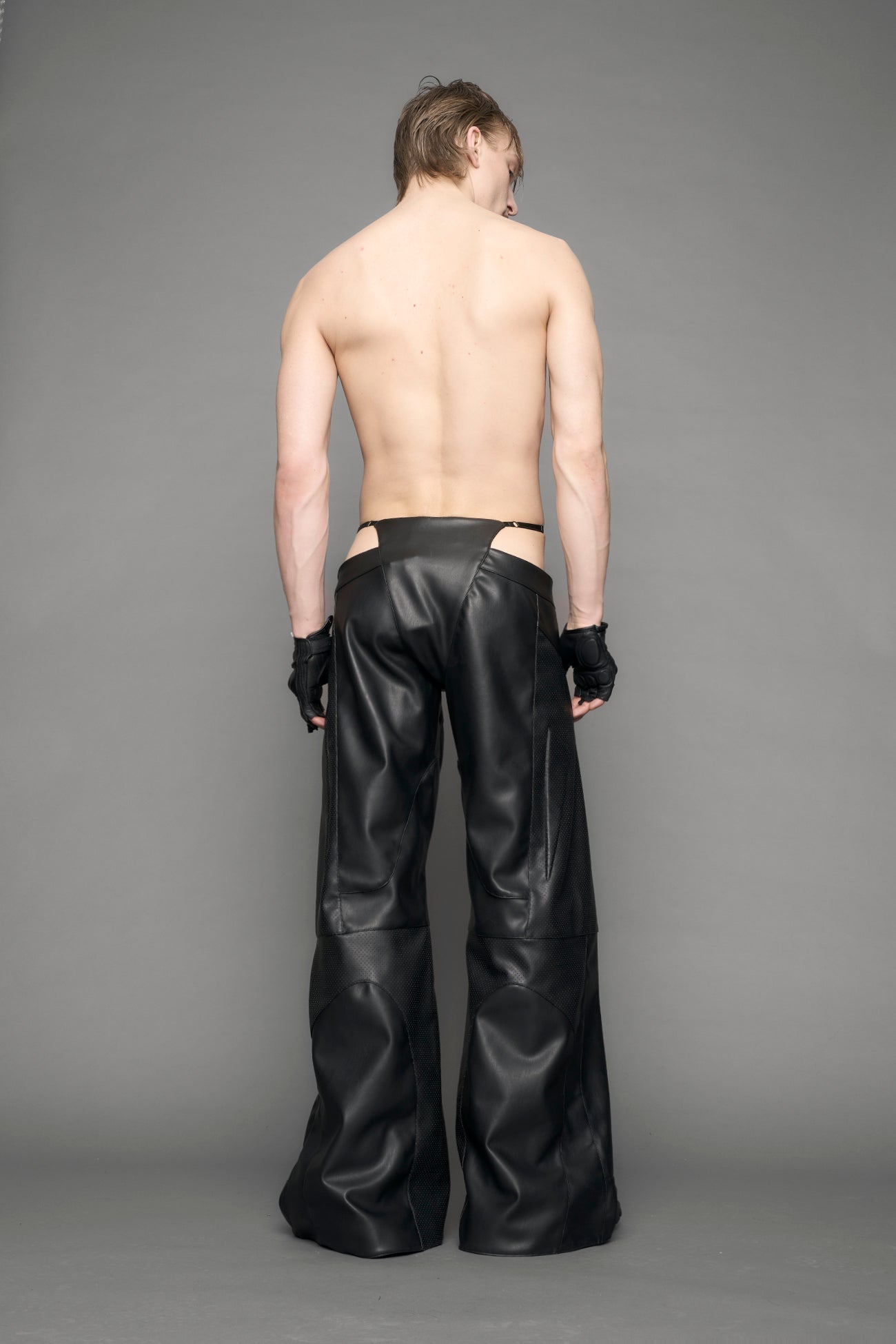 model wearing black vegan leather thong pants