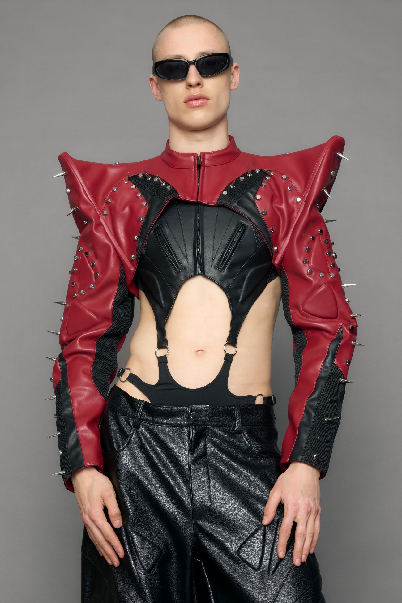 Model wearing a red studded leather choker jacket with cut-out design 