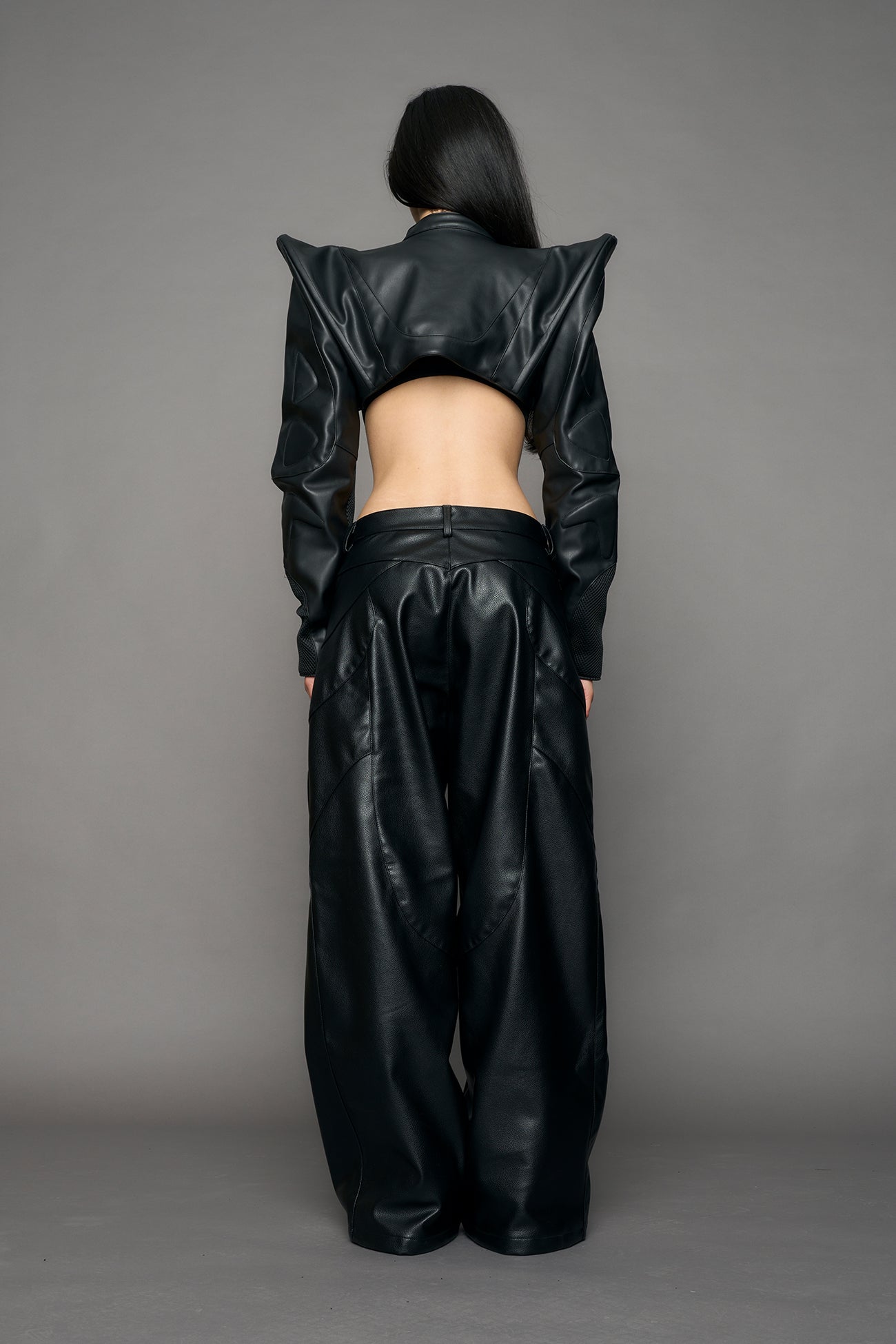 Model wearing a black leather choker jacket with cut-out design 