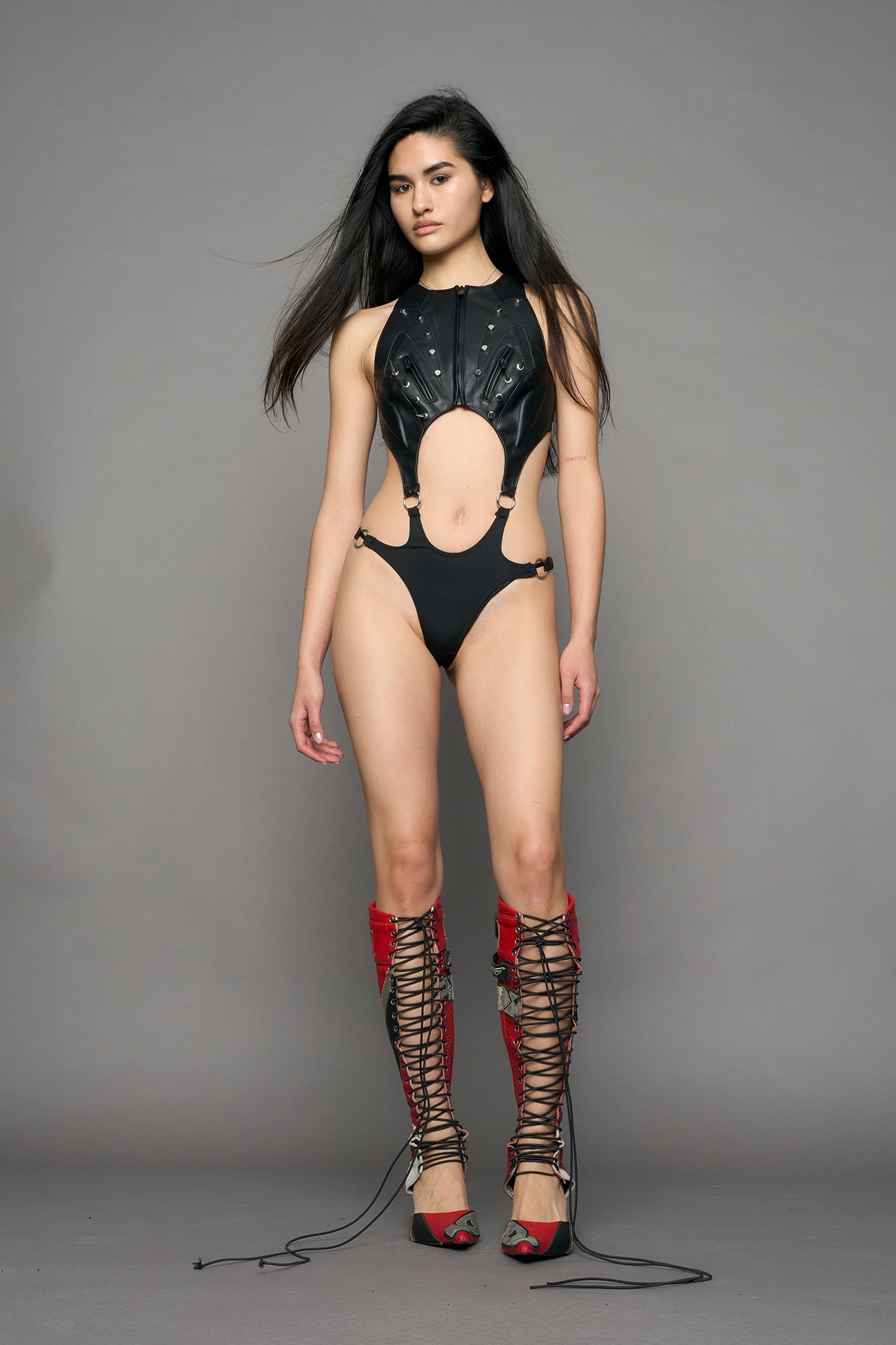 model wearing black studded moto body with cut out design