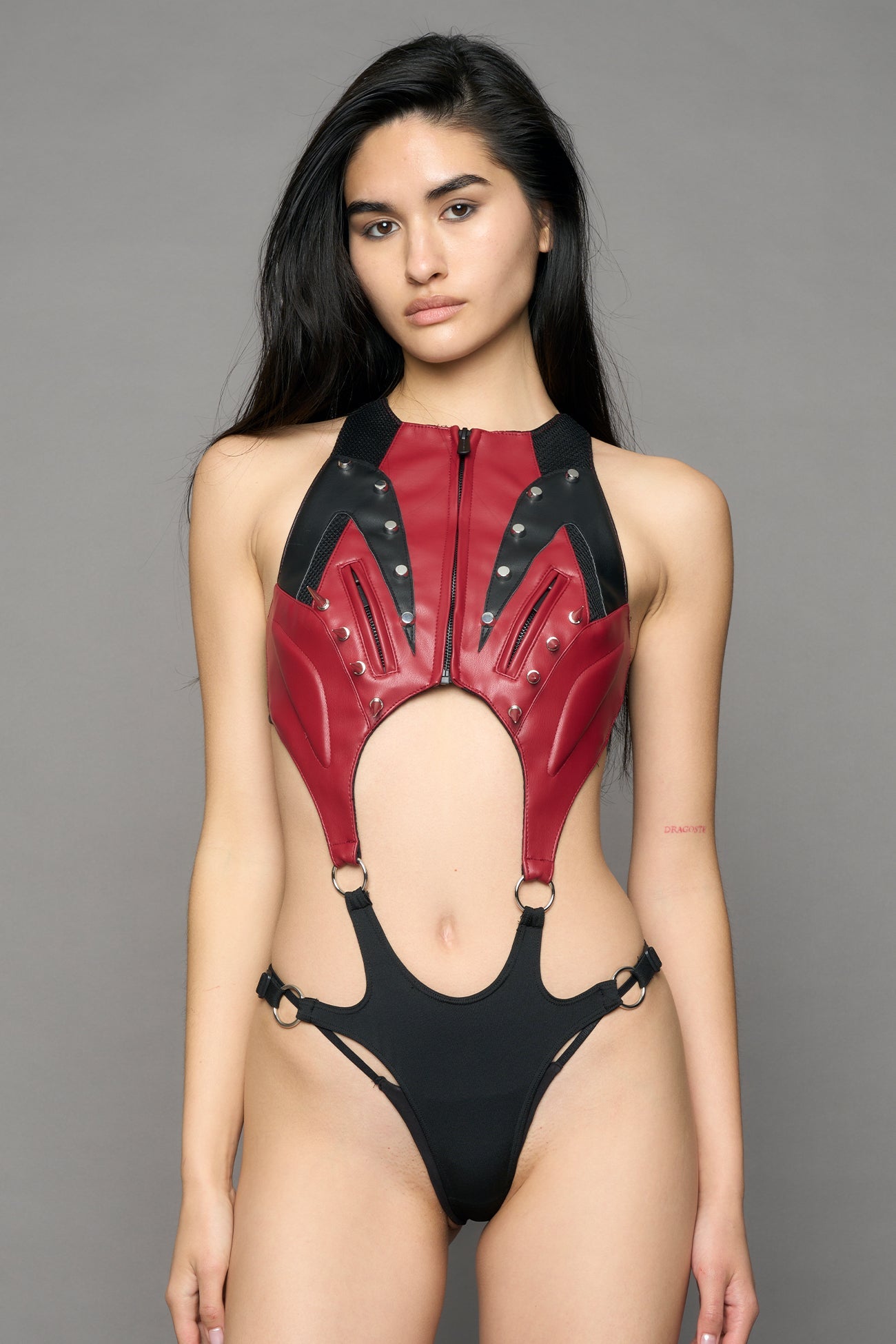 model wearing red studded moto body with cut out design