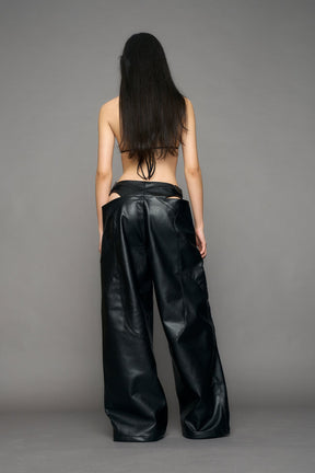 model wearing black pu leather trousers with thong design and moto style highlights