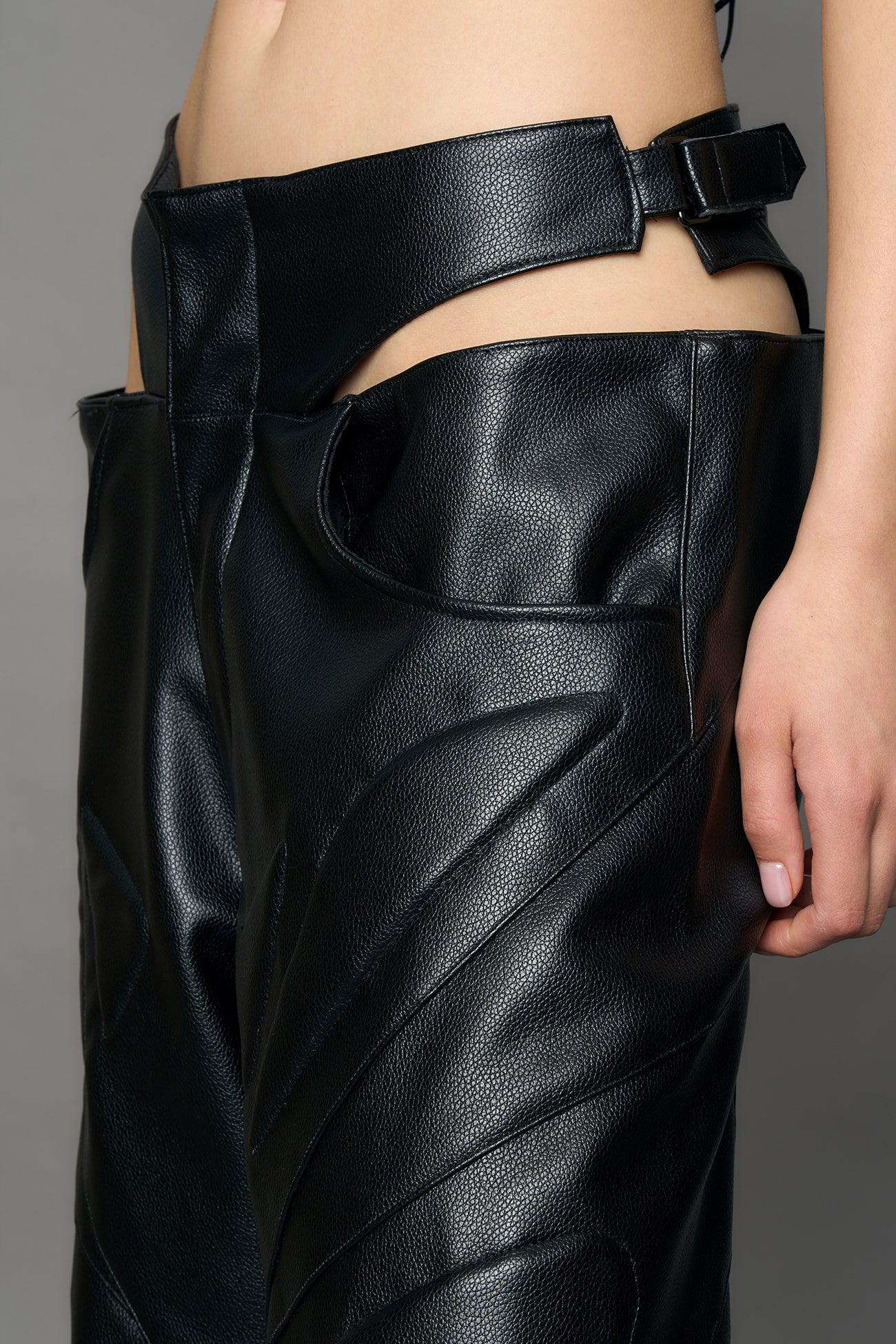 model wearing black pu leather trousers with thong design and moto style highlights
