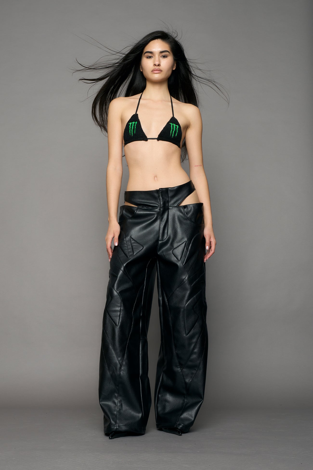 model wearing black pu leather trousers with thong design and moto style highlights