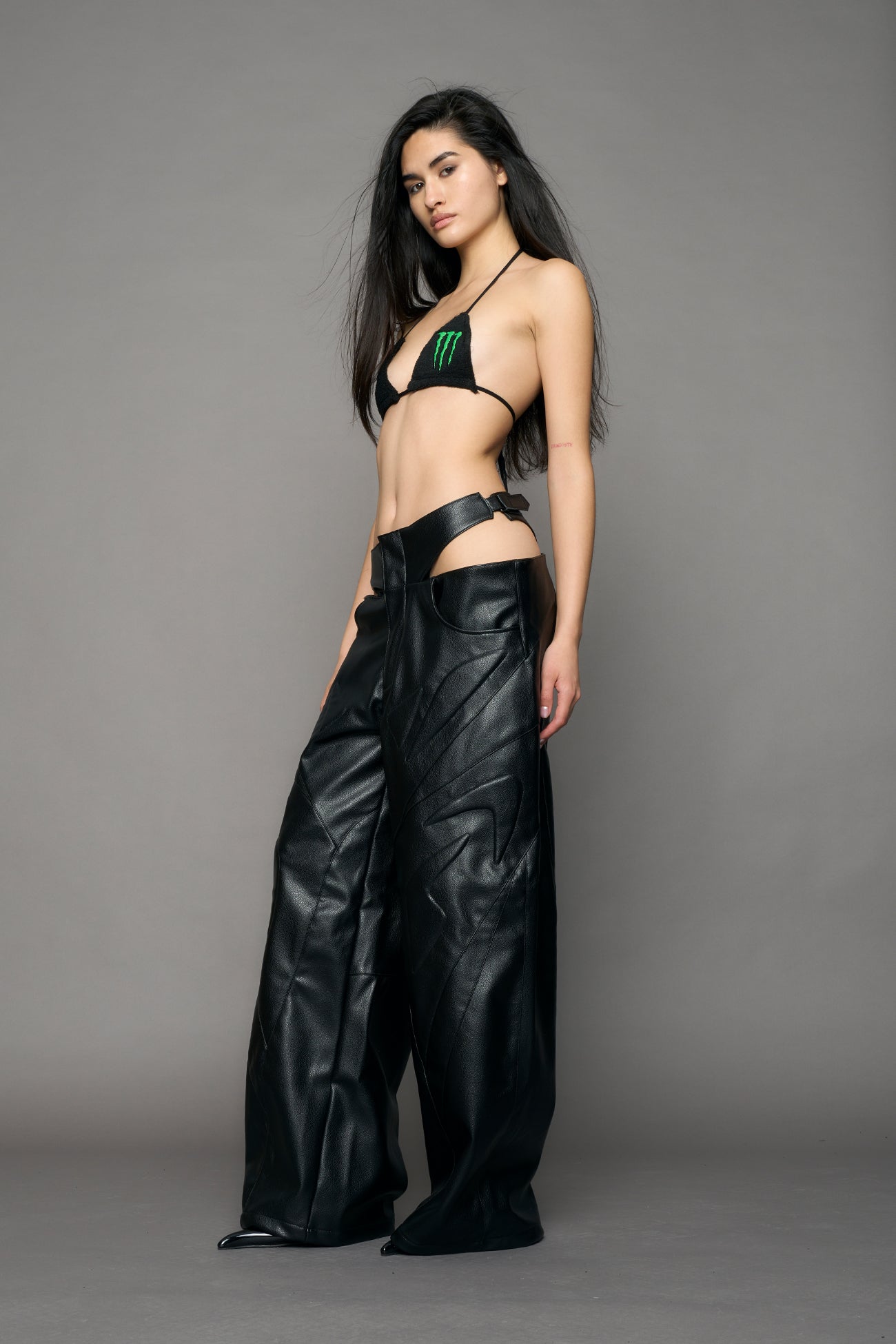 model wearing black pu leather trousers with thong design and moto style highlights